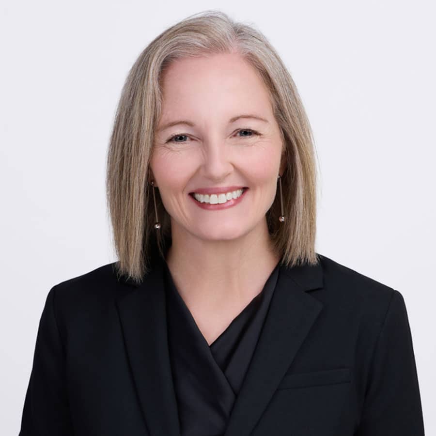 Jill Webster, attorney at Briones PC. Professional headshot, smiling in a black blazer against a white background.